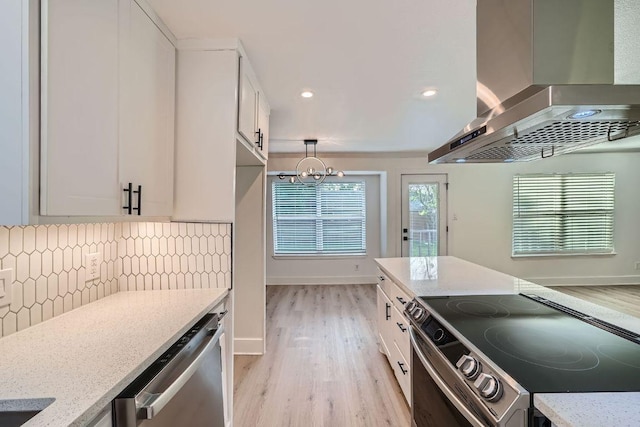 6102 Amber Pass, Austin, TX 78745 - kitchen with range with electric cooktop, wall chimney range hood, stainless steel dishwasher, light wood-type flooring, and a chandelier