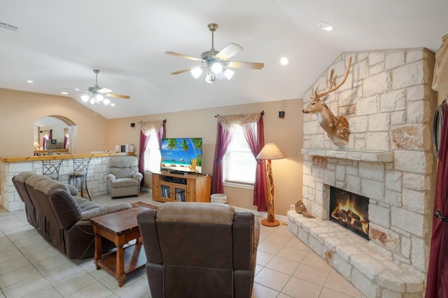 213 S Buffalo Pass, Georgetown, TX 78633 - living room featuring vaulted ceiling, a ceiling fan, a stone fireplace, light tile patterned flooring, and arched walkways