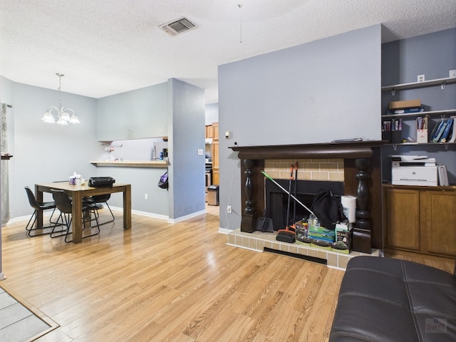 2901 San Jacinto Blvd Unit 110, Austin, TX 78705 - living area with a textured ceiling, a chandelier, and wood finished floors