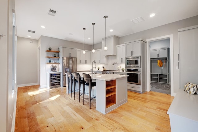 2005 Palo Duro Rd, Austin, TX 78757 - kitchen with open shelves, appliances with stainless steel finishes, beverage cooler, light countertops, and a kitchen bar
