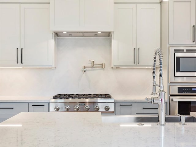 2005 Palo Duro Rd, Austin, TX 78757 - kitchen featuring appliances with stainless steel finishes, light stone counters, and tasteful backsplash