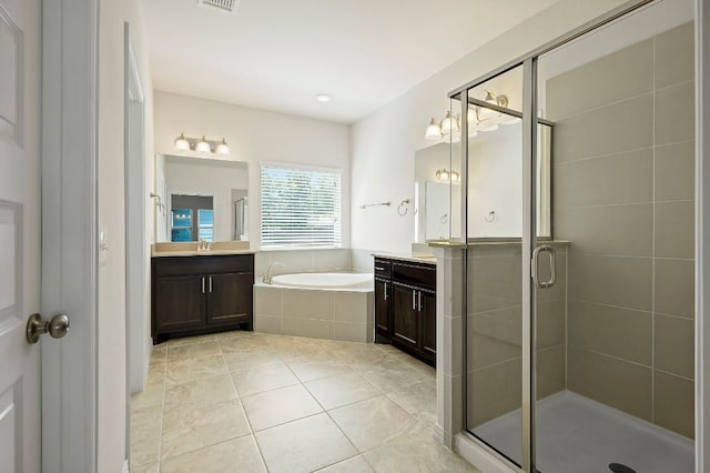 8821 Cattle Baron Path, Austin, TX 78747 - bathroom featuring a garden tub, two vanities, a stall shower, and tile patterned flooring