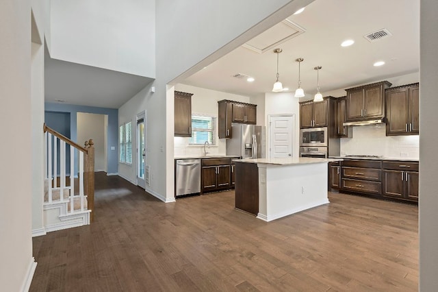 8821 Cattle Baron Path, Austin, TX 78747 - kitchen featuring stainless steel appliances, dark brown cabinets, under cabinet range hood, light countertops, and tasteful backsplash