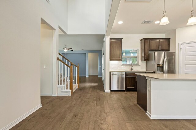 8821 Cattle Baron Path, Austin, TX 78747 - kitchen featuring appliances with stainless steel finishes, light countertops, dark wood-style floors, dark brown cabinetry, and tasteful backsplash