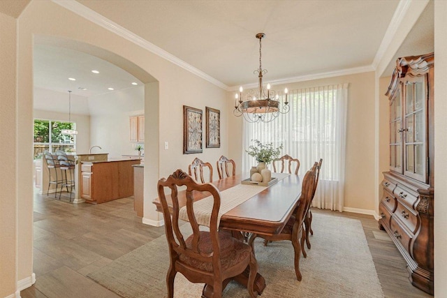 10320 Hansa Cv, Austin, TX 78739 - dining space featuring a chandelier, arched walkways, light wood finished floors, ornamental molding, and recessed lighting