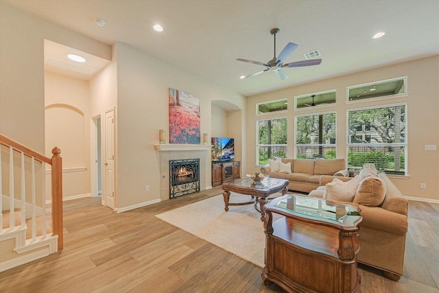 10320 Hansa Cv, Austin, TX 78739 - living area with light wood-style floors, recessed lighting, a lit fireplace, stairs, and ceiling fan