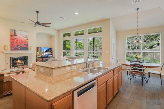 10320 Hansa Cv, Austin, TX 78739 - kitchen with dishwasher, wood finished floors, a kitchen island with sink, light stone countertops, and open floor plan