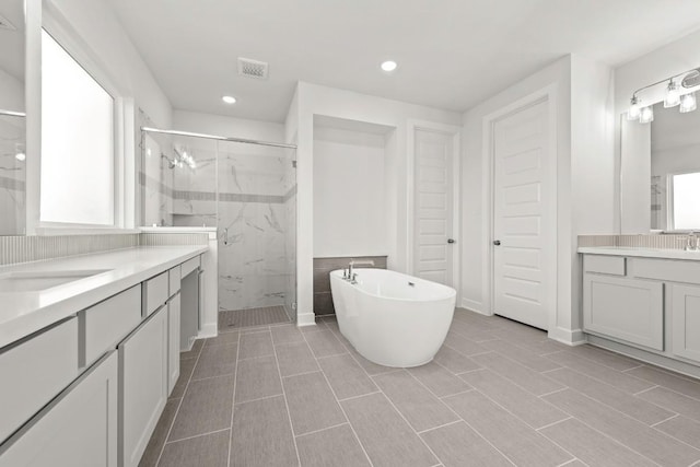401 Golden Sage Ave, Georgetown, TX 78633 - bathroom with a marble finish shower, two vanities, a soaking tub, and recessed lighting