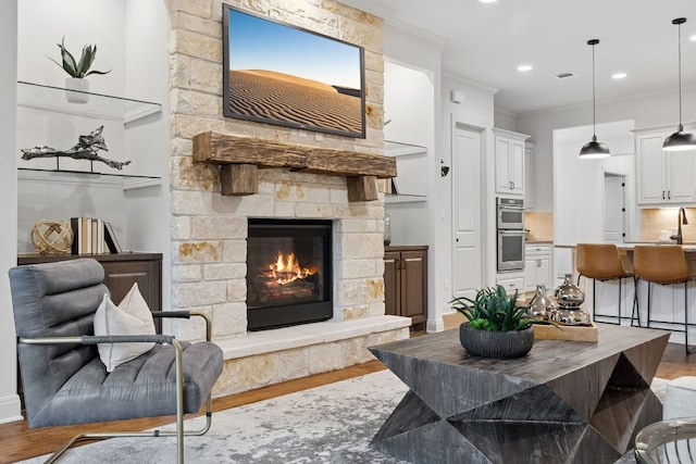 377 Bristlecone Dr, Driftwood, TX 78619 - living room featuring wood finished floors, a fireplace, crown molding, and recessed lighting