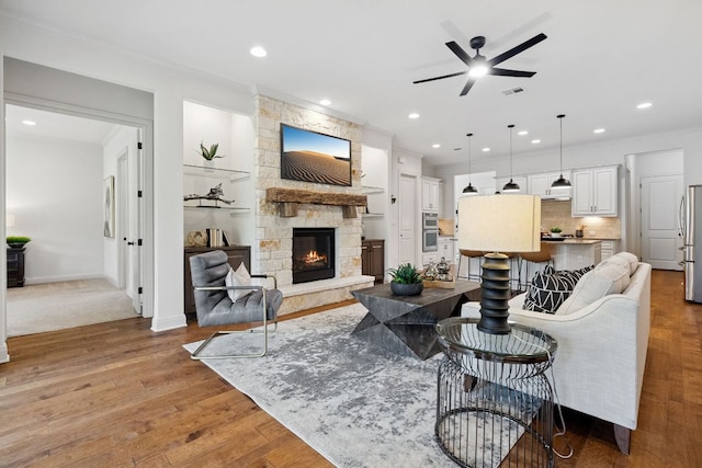 377 Bristlecone Dr, Driftwood, TX 78619 - living area featuring ceiling fan, a stone fireplace, wood finished floors, recessed lighting, and ornamental molding