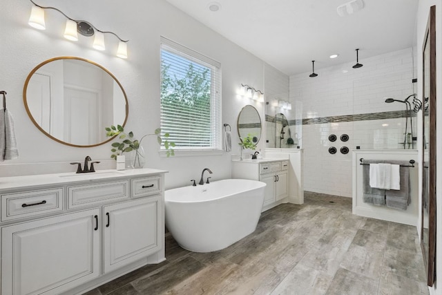 377 Bristlecone Dr, Driftwood, TX 78619 - full bath featuring two vanities, walk in shower, a freestanding bath, and wood finished floors