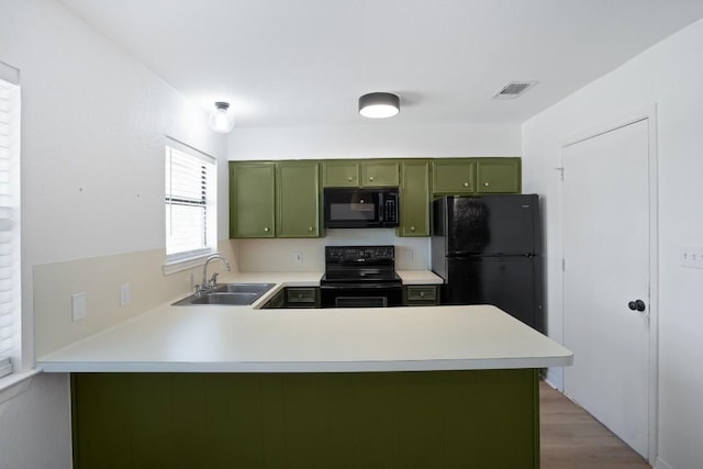 1004 Scenic Dr, Georgetown, TX 78626 - kitchen with green cabinets, black appliances, light countertops, and a peninsula