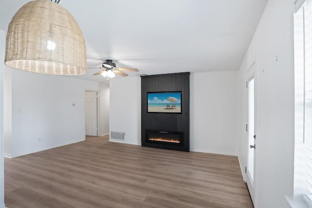 1004 Scenic Dr, Georgetown, TX 78626 - unfurnished living room featuring wood finished floors, a ceiling fan, and a fireplace