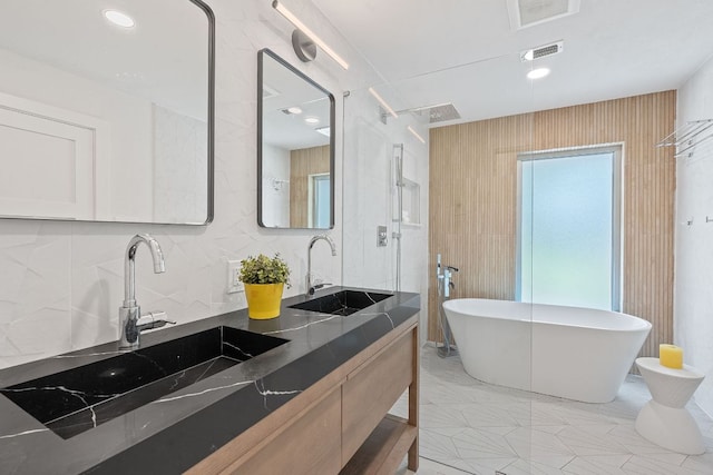 4405 Greystone Dr, Austin, TX 78731 - full bath featuring a freestanding tub, double vanity, and tasteful backsplash