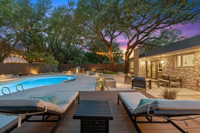 4405 Greystone Dr, Austin, TX 78731 - pool at dusk with an outdoor living space, a fenced backyard, and a patio area