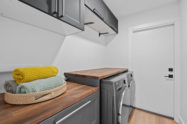 4405 Greystone Dr, Austin, TX 78731 - laundry area featuring cabinet space, washer and dryer, and light wood finished floors