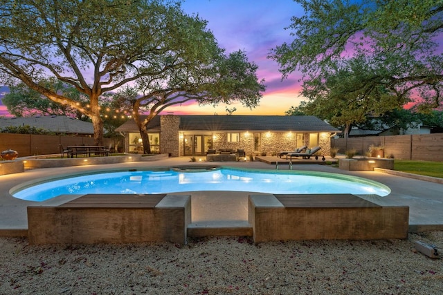 4405 Greystone Dr, Austin, TX 78731 - pool at dusk featuring a hot tub, a fenced backyard, and a patio