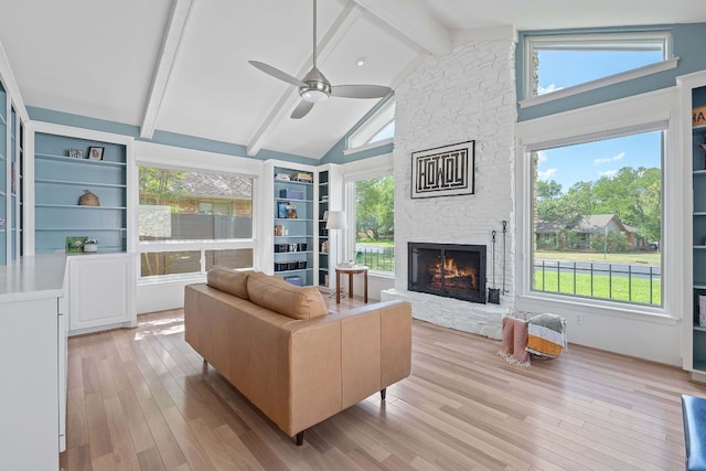 4405 Greystone Dr, Austin, TX 78731 - living room with a ceiling fan, a fireplace, beamed ceiling, light wood-style floors, and high vaulted ceiling