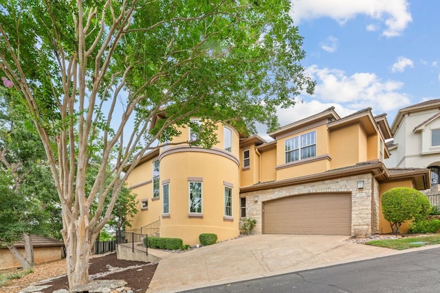 2800 Waymaker Way Unit 63, Austin, TX 78746 - view of front facade featuring stucco siding, stone siding, driveway, and an attached garage