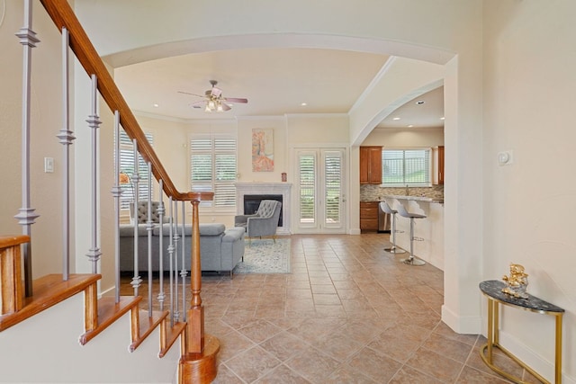 2800 Waymaker Way Unit 63, Austin, TX 78746 - living area with a ceiling fan, stairs, arched walkways, crown molding, and a fireplace