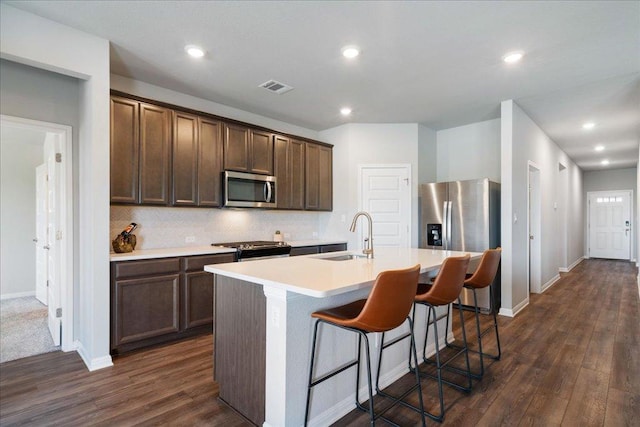111 El Capitan Loop, Dripping Springs, TX 78620 - kitchen with stainless steel appliances, dark wood finished floors, light countertops, a center island with sink, and recessed lighting