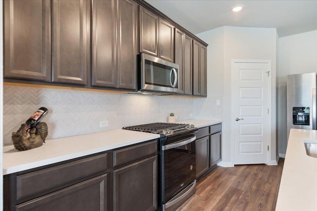111 El Capitan Loop, Dripping Springs, TX 78620 - kitchen with appliances with stainless steel finishes, dark brown cabinets, light countertops, dark wood finished floors, and recessed lighting