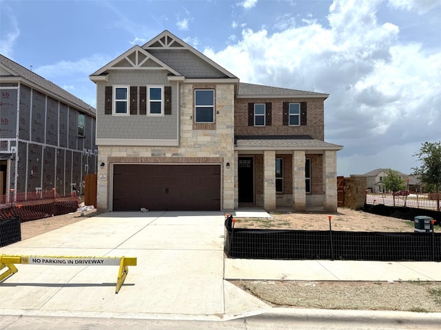 4805 Mozzafiato Ln, Round Rock, TX 78665 - view of front facade featuring stone siding, a fenced front yard, a garage, driveway, and roof with shingles