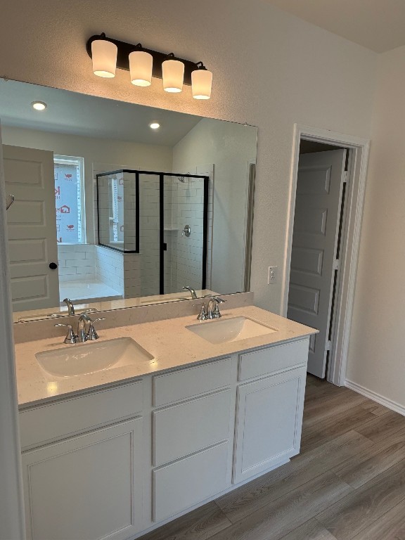 4805 Mozzafiato Ln, Round Rock, TX 78665 - full bathroom with a stall shower, wood finished floors, double vanity, and a tub