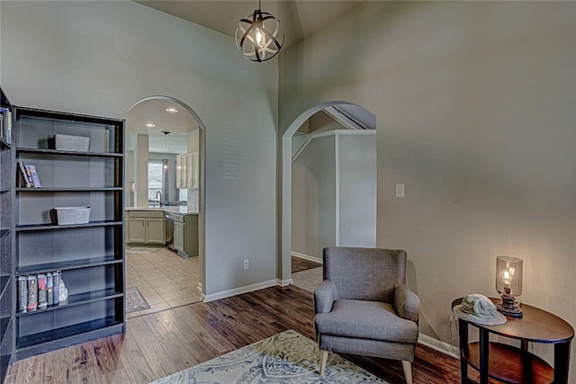 2712 Kickapoo Cavern Dr, Pflugerville, TX 78660 - living area featuring arched walkways, a high ceiling, and wood finished floors