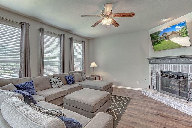 2712 Kickapoo Cavern Dr, Pflugerville, TX 78660 - living area with plenty of natural light, a ceiling fan, dark wood-style floors, a textured ceiling, and a fireplace