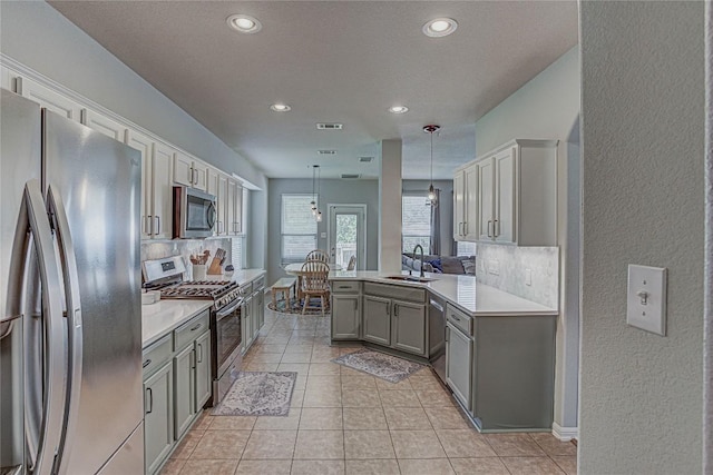 2712 Kickapoo Cavern Dr, Pflugerville, TX 78660 - kitchen featuring stainless steel appliances, gray cabinets, a textured wall, backsplash, and recessed lighting