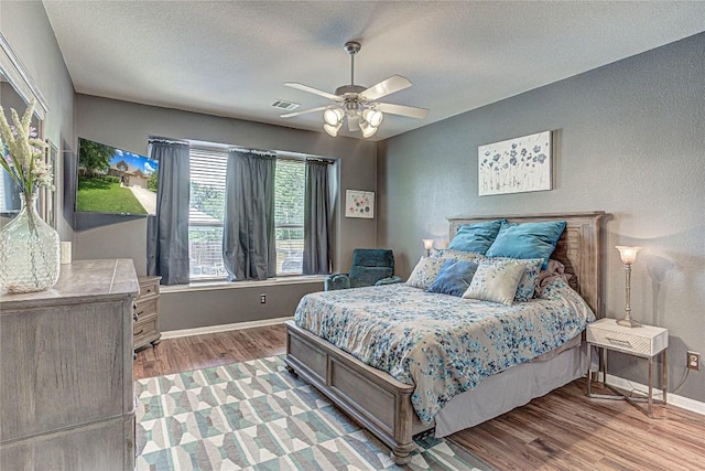 2712 Kickapoo Cavern Dr, Pflugerville, TX 78660 - bedroom with light wood-type flooring, ceiling fan, and a textured ceiling
