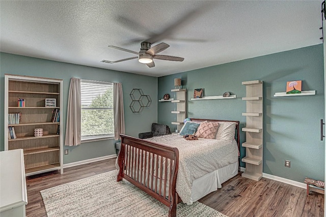 2712 Kickapoo Cavern Dr, Pflugerville, TX 78660 - bedroom featuring wood finished floors, a textured ceiling, and a ceiling fan