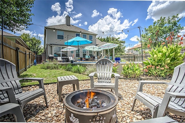 2712 Kickapoo Cavern Dr, Pflugerville, TX 78660 - rear view of property with a fire pit, a fenced backyard, a patio, and a swimming pool