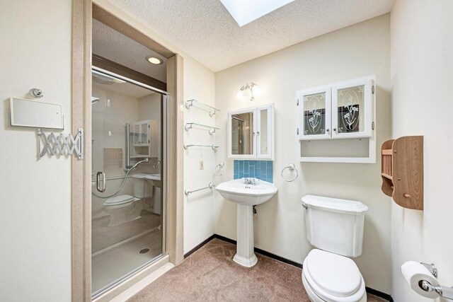 6606 Lancret Hill Dr, Austin, TX 78745 - bathroom with a skylight, a shower stall, and a textured ceiling