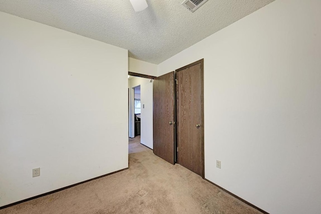 6606 Lancret Hill Dr, Austin, TX 78745 - unfurnished bedroom featuring light colored carpet, a textured ceiling, a closet, and a ceiling fan