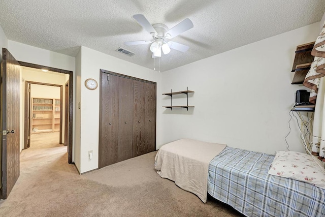 6606 Lancret Hill Dr, Austin, TX 78745 - bedroom featuring carpet flooring, a closet, a textured ceiling, and ceiling fan