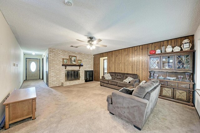 6606 Lancret Hill Dr, Austin, TX 78745 - living room with light colored carpet, a ceiling fan, a textured ceiling, wood walls, and a brick fireplace