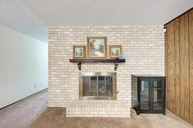 6606 Lancret Hill Dr, Austin, TX 78745 - unfurnished living room with a brick fireplace, carpet floors, a textured ceiling, and wooden walls