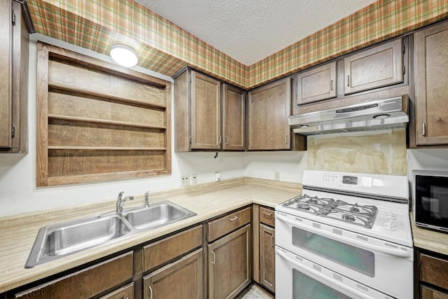 6606 Lancret Hill Dr, Austin, TX 78745 - kitchen with range with two ovens, under cabinet range hood, a textured ceiling, light countertops, and wallpapered walls