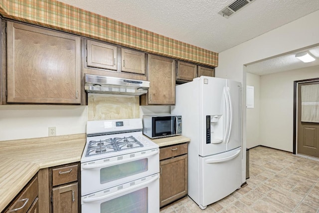 6606 Lancret Hill Dr, Austin, TX 78745 - kitchen featuring white appliances, under cabinet range hood, light countertops, and a textured ceiling