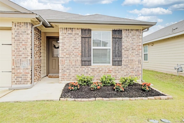 114 Creek Hollow Dr, Hutto, TX 78634 - entrance to property with brick siding, a yard, and an attached garage