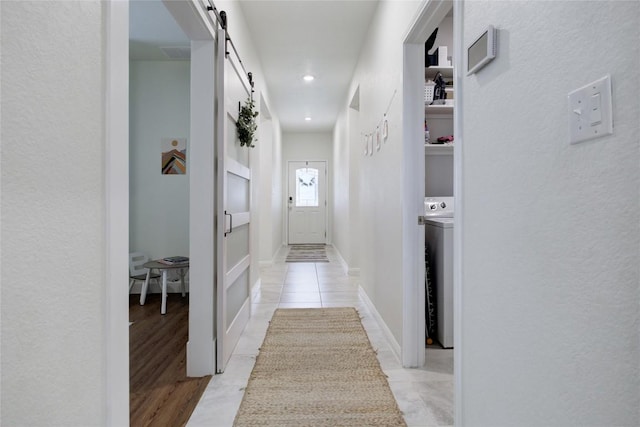 114 Creek Hollow Dr, Hutto, TX 78634 - corridor featuring a barn door and washer / dryer