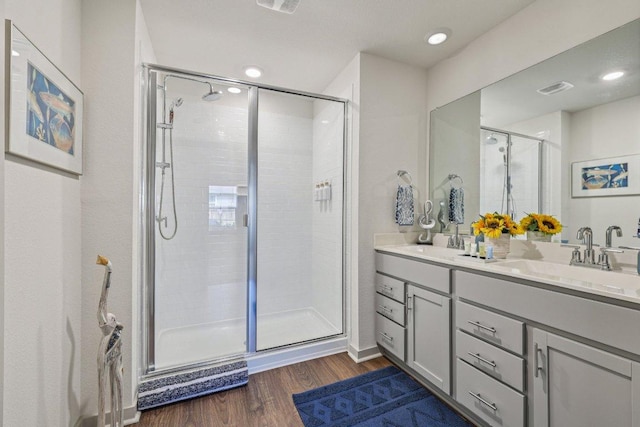 111 Krause Springs Dr, Hutto, TX 78634 - bathroom featuring a stall shower, double vanity, and wood finished floors