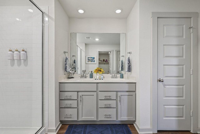 111 Krause Springs Dr, Hutto, TX 78634 - bathroom with a stall shower, double vanity, wood finished floors, and recessed lighting