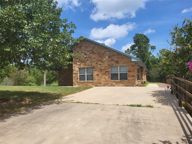 236 Makaha Dr, Bastrop, TX 78602 - view of property exterior featuring stone siding, a lawn, and concrete driveway