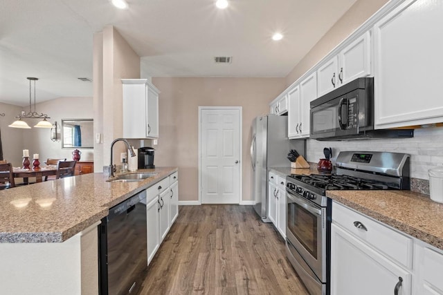 1111 Whitley Dr, Leander, TX 78641 - kitchen with black appliances, white cabinets, wood finished floors, decorative backsplash, and recessed lighting