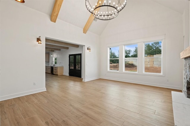 280 Bali Hai Ln, Bastrop, TX 78602 - unfurnished living room featuring a chandelier, high vaulted ceiling, a stone fireplace, light wood-style floors, and beamed ceiling