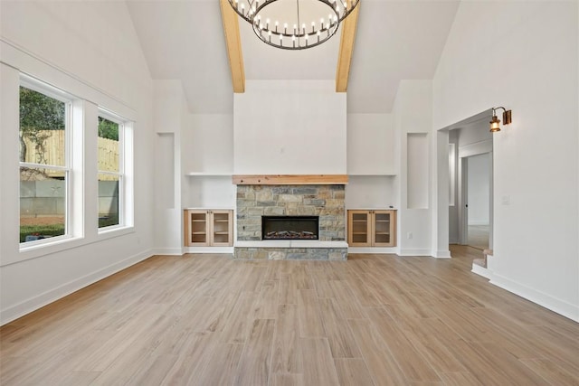 280 Bali Hai Ln, Bastrop, TX 78602 - unfurnished living room with high vaulted ceiling, a chandelier, light wood-style flooring, a fireplace, and built in features