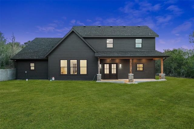 280 Bali Hai Ln, Bastrop, TX 78602 - back of house at dusk featuring a yard, a patio, and roof with shingles